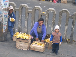 A woman selling bananas with her kids
